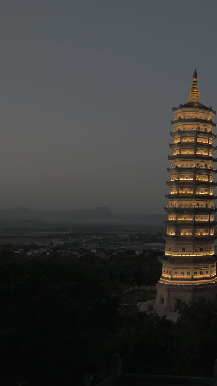 Pagoda iluminada e imponente al anochecer en un paisaje rural