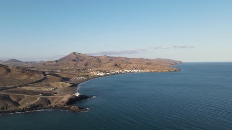 video aéreo de drones de un pequeño pueblo en el lado costero de la isla fuerteventura mientras se pone el sol