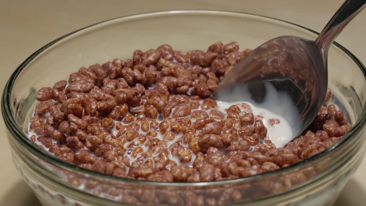 metiendo algunos cereales de chocolate no saludables en un tazón de leche
