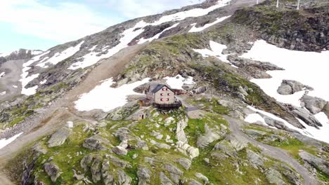 house standing on a steep rocky slope partly covered in snow in the alps in kaernten, austria