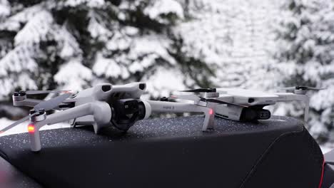 two drones positioned on a surface in a snowy environment
