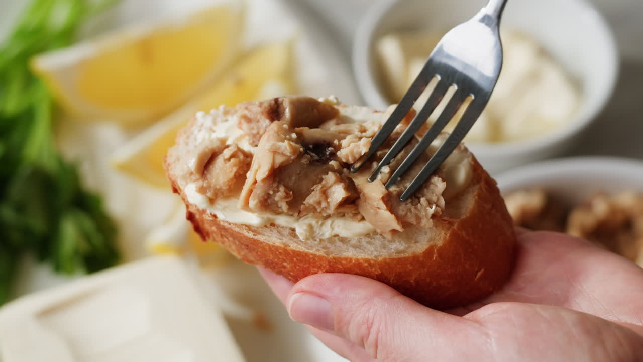 Smoked cod liver in oil in open tin can with fresh greens on wooden table. Seafoods delicacy. High quality 4k footage
