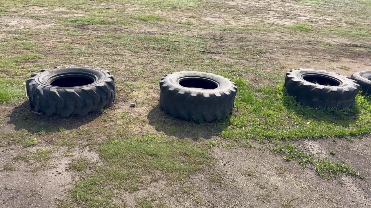 Tyres in a row at a field. Tyres are used to stop cars or create a barrier.