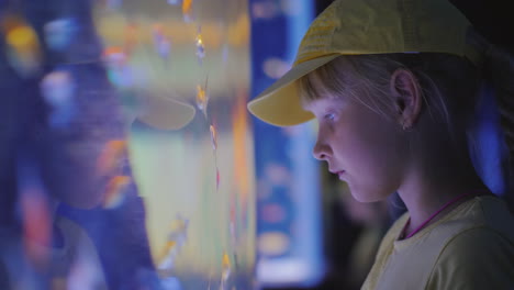 Side-View-Little-Girl-Looking-At-A-Huge-Aquarium-With-Sea-Fishes-Inspiration-And-Impressions-Concept