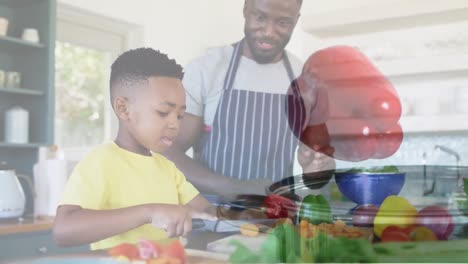 Animation-of-red-pepper-over-happy-african-american-father-and-son-preparing-meal