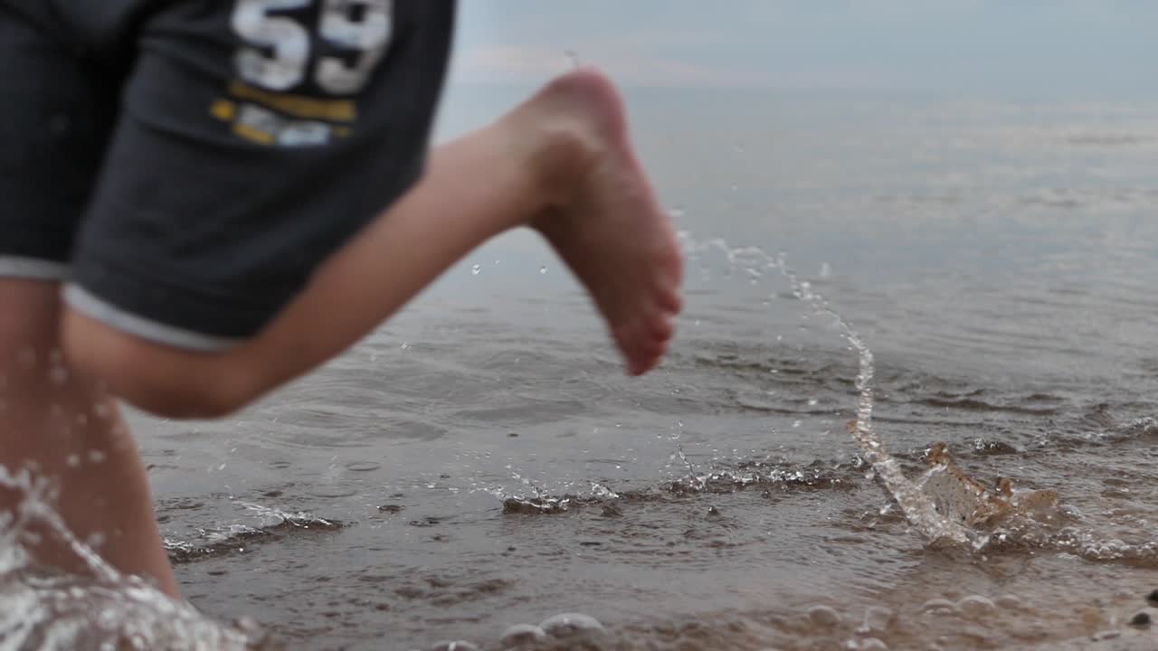 아이는 해변을 따라 달리고 얼굴을 보지 못한다