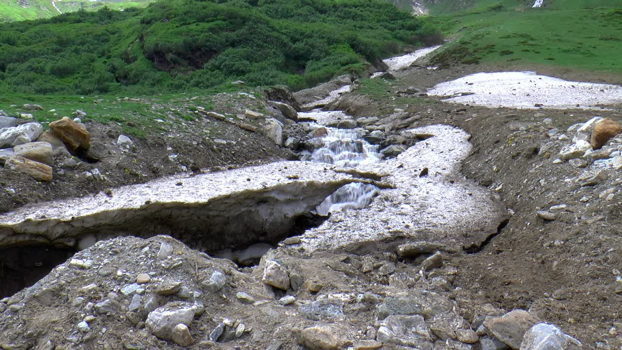la cascada fluye bajo la nieve derretida. tiempo de obturación prolongado