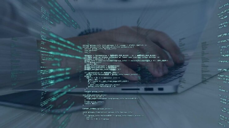 Mand løfter hænderne og begynder at skrive på en bærbar computer, mens grønne kodesøjler udvider sig omkring hænderne til kodning.