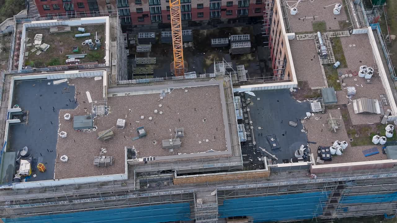 Appartamenti a torre abbandonati in Delamere Road, Cheshunt, Hertfordshire, Regno Unito, mentre il drone si sposta a destra, rivelando il tetto, le impalcature e il vicino cantiere di riqualificazione