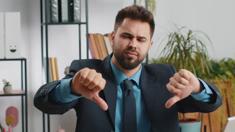 upset businessman showing thumbs down dislike bad work disapproval dissatisfied feedback at office