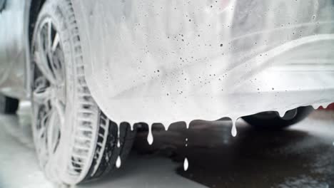 close-up of car with foam dripping during a wash