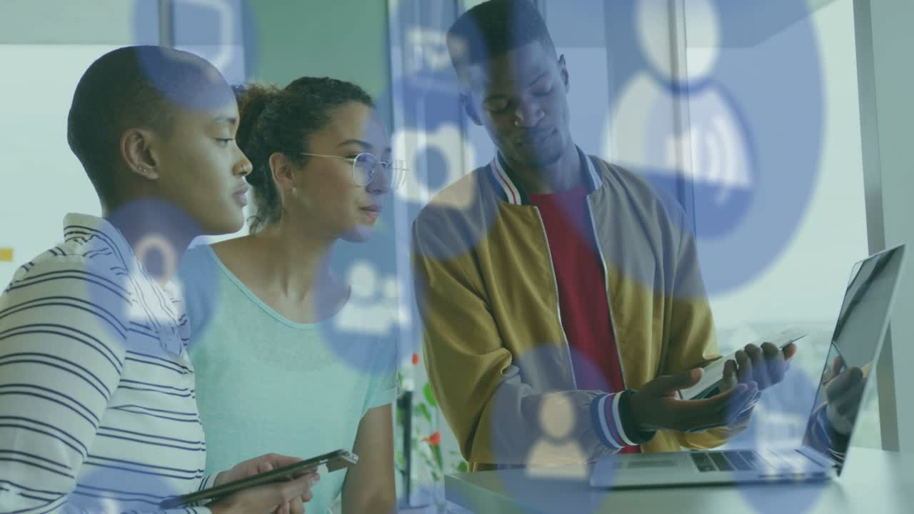 Team standing by window man tapping tablet gesturing laptop reviewing social metrics icons sweeping