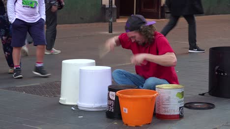 a street musician plays drums on a london street