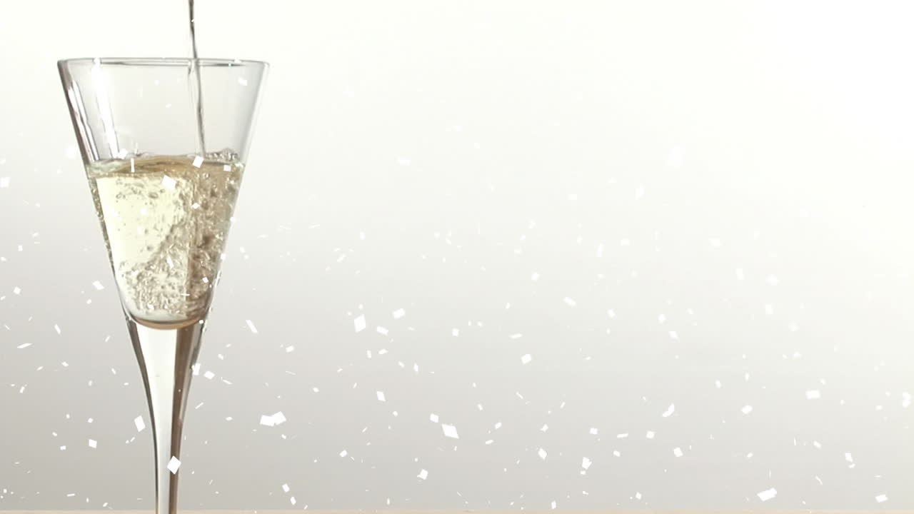 Animazione di neve che cade su un bicchiere di champagne su sfondo bianco