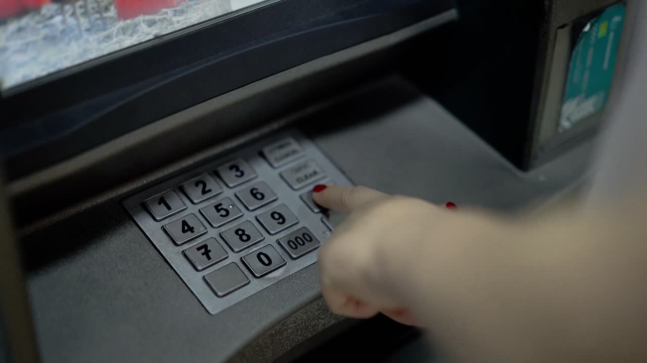 Una giovane ragazza digita il PIN al bancomat 1