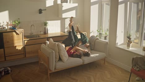 couple playing on a couch in a sunny living room