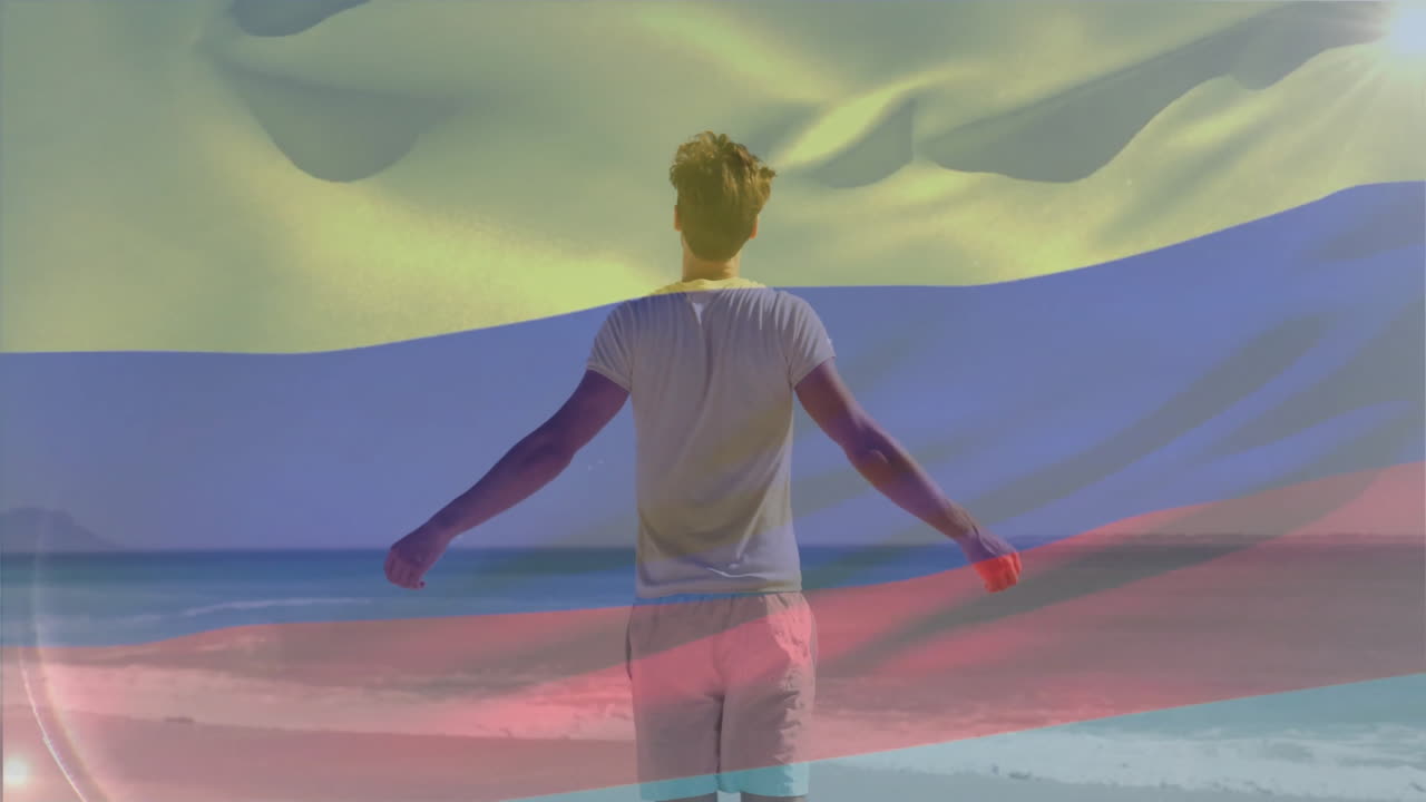 Man standing on beach with arms outstretched under colorful aurora animation