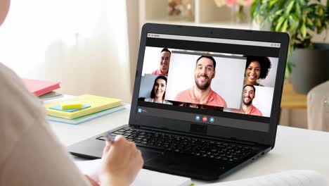 education,-online-school-and-distant-learning-concept--student-woman-with-notebook-and-book-having-video-call-on-laptop-computer-at-home