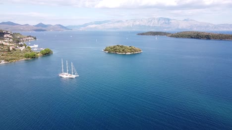 Big-Luxury-Boat-Floats-in-Nidri-Bay-at-Lefkada,-Greece---Aerial-Forward