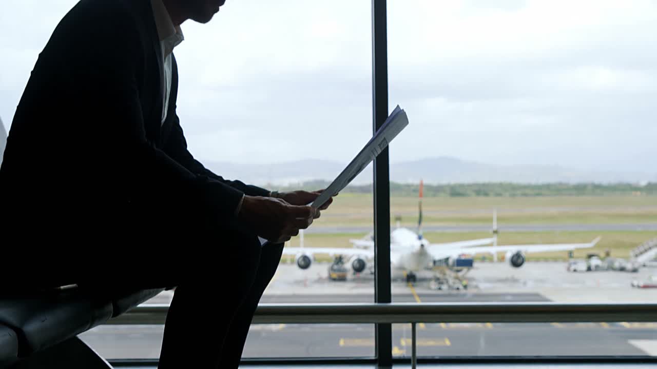 hombre de negocios sentado en el aeropuerto y leyendo el periódico