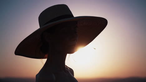 elegant woman in hat at sunset