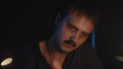 a man with a mustache in a dimly lit setting