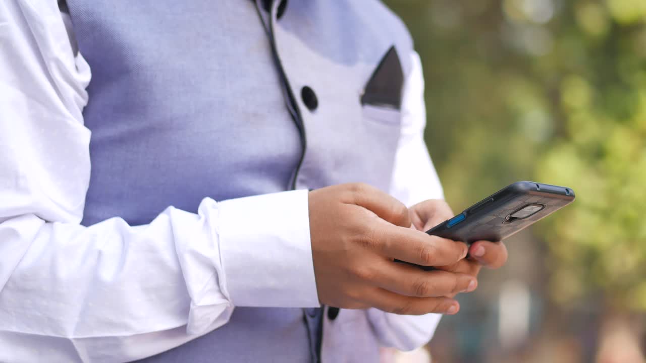 primer plano de la mano de un joven usando un teléfono inteligente