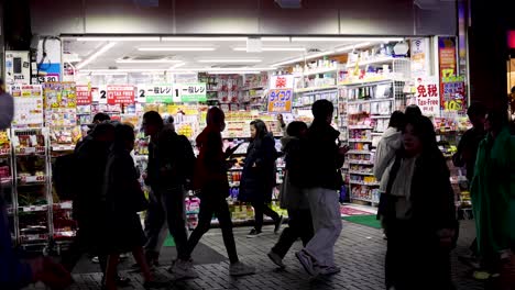 pedestrians walking past a brightly lit store