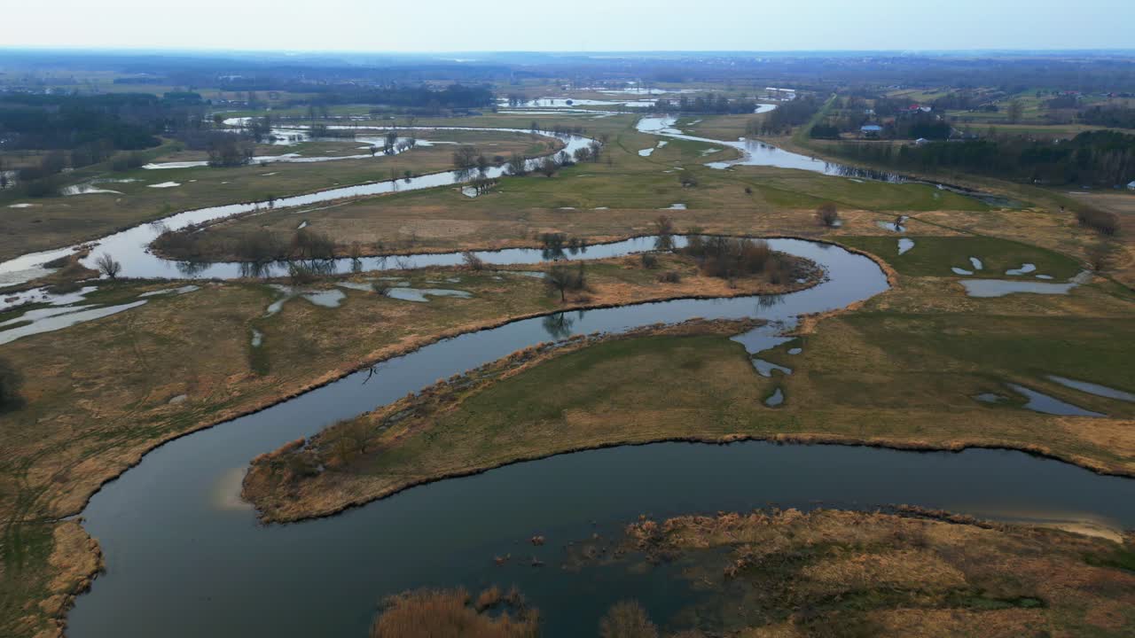 vista aérea de primavera de campos inundados y río serpenteante en el campo en un día soleado