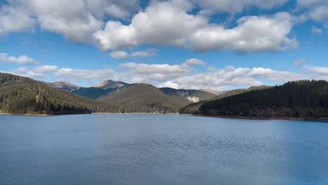 timelapse of clouds moving over the bolboci lake and mountain range in summer in romania