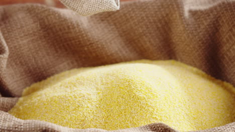 cornmeal or polenta being poured into a burlap sack