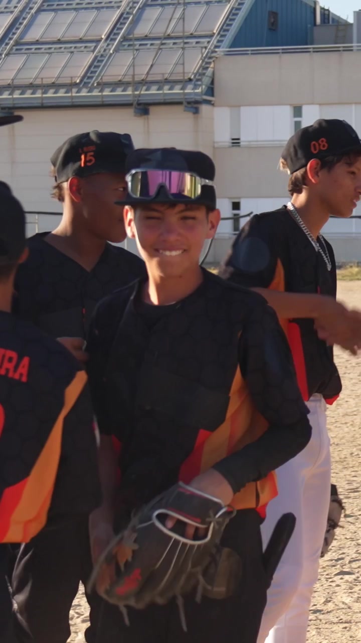 Squadra giovanile di baseball che festeggia e si batte il cinque dopo una partita