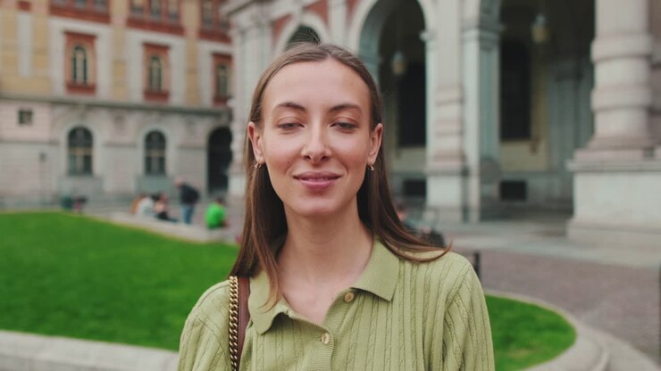 Giovane donna sorridente che guarda la fotocamera all'aperto