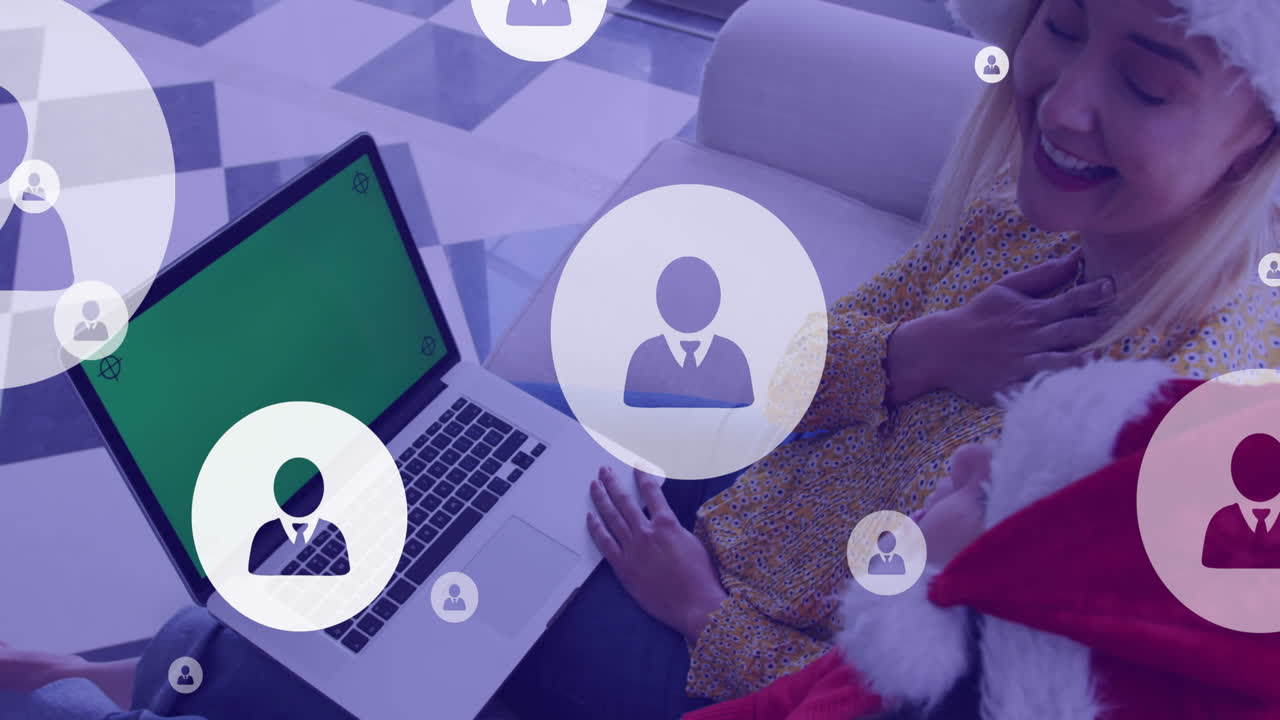 animación de iconos digitales sobre madre y hija caucásicas con computadora portátil en navidad