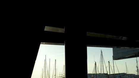 silhouette of sailboats against golden sunset, marina view