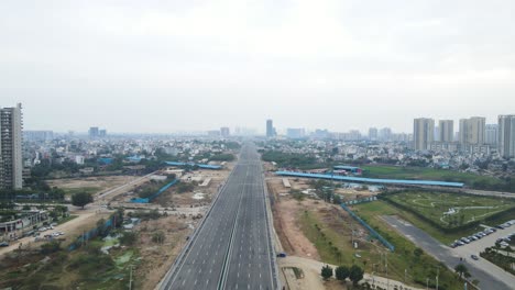 aerial drone shot highlighting an unfinished residential tower near dwarka expressway, standing tall against the expanding city skyline.