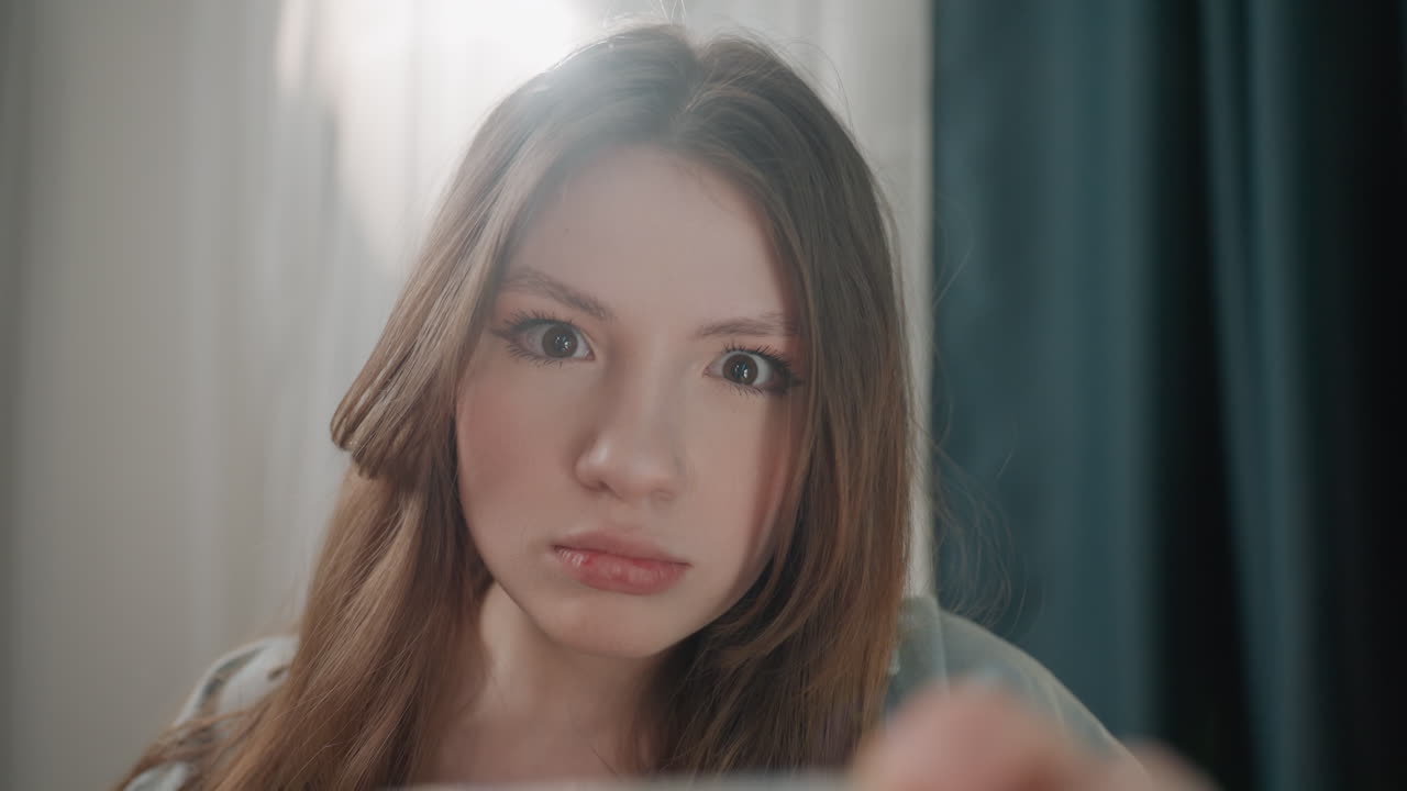 Caucasian woman inspecting blood pressure monitor up close in bedroom curtain backdrop, home vlogger testing cuff device, medical student practice scene, focused expression and subtle worry, soft