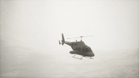helicóptero volando en cámara lenta extrema cerca de las montañas con niebla