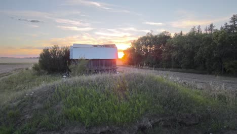 Colourful-sunset-revealed-behind-a-forest-and-abandoned-barns-in-southern-Alberta