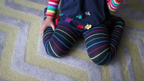 niño sentado en una alfombra con ropa de colores