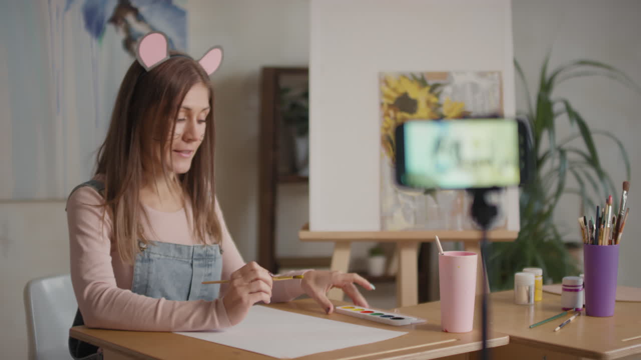 Woman painting online tutorial with mouse ears