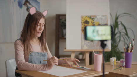 mujer pintando tutorial en línea con orejas de ratón