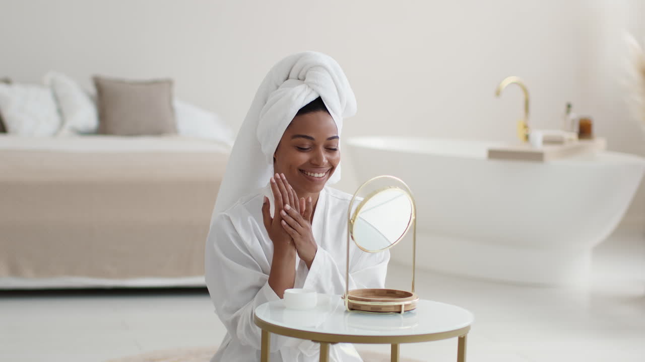 Woman applying face cream in a luxurious bathroom