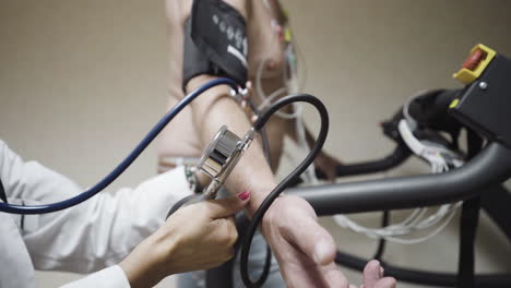 checking blood pressure levels on a walking athlete on treadmill