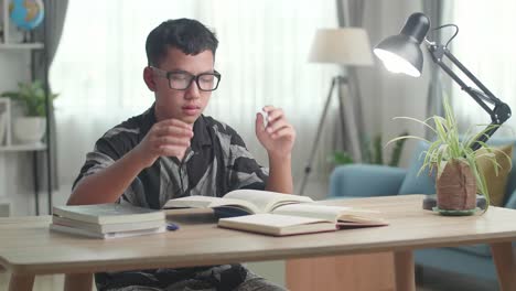 asia boy feel pain eyestrain rubbing dry irritated eyes fatigued from doing home work