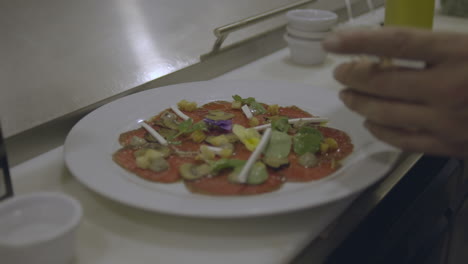 Der-Erfahrene-Koch-Fügt-Einer-Köstlichen-Pizza-Sorgfältig-Eine-Reihe-Zusätzlicher-Zutaten-Hinzu,-Darunter-Frische-Tomaten-Und-Herzhafte-Pilze,-Um-Den-Geschmack-Und-Die-Optik-Zu-Verbessern