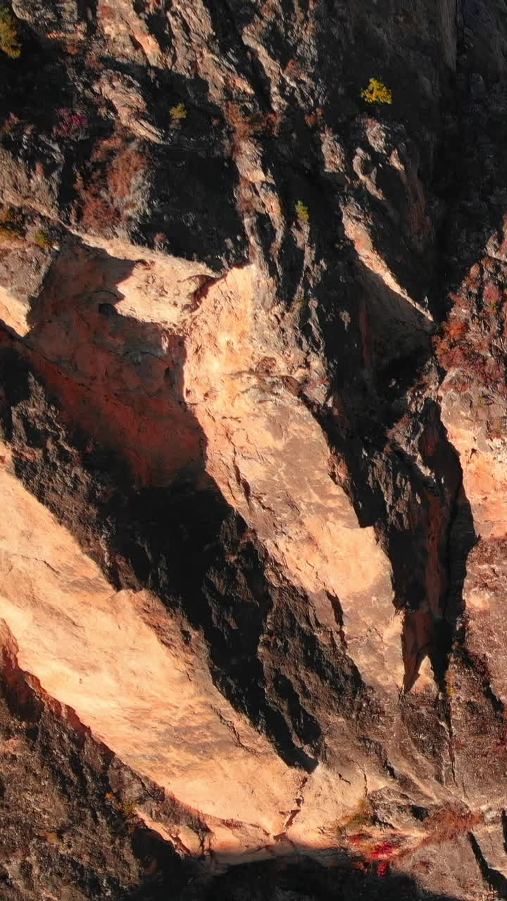 Luci e ombre su una parete rocciosa aspra e frastagliata