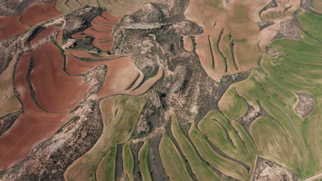 aerial back traveling spain hills pasture farmland and red soil