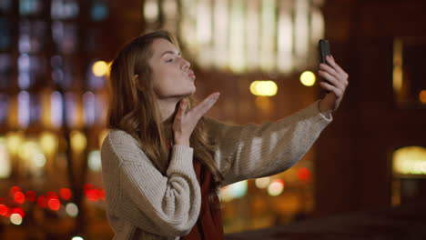 funny woman making selfie by mobile phone outside. cute girl showing duck lips.