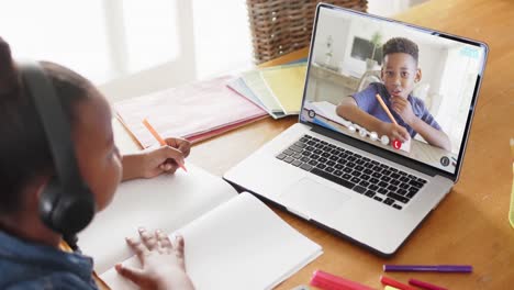 Composition-of-african-american-schoolgirl-on-laptop-online-learning-with-african-american-schoolboy